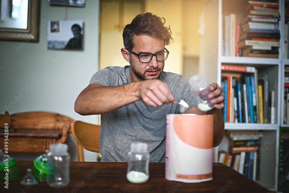 © Arnéll Koegelenberg/peopleimages.com - Hes learning everyday. Cropped shot of a single father preparing a bottle for his baby at home.