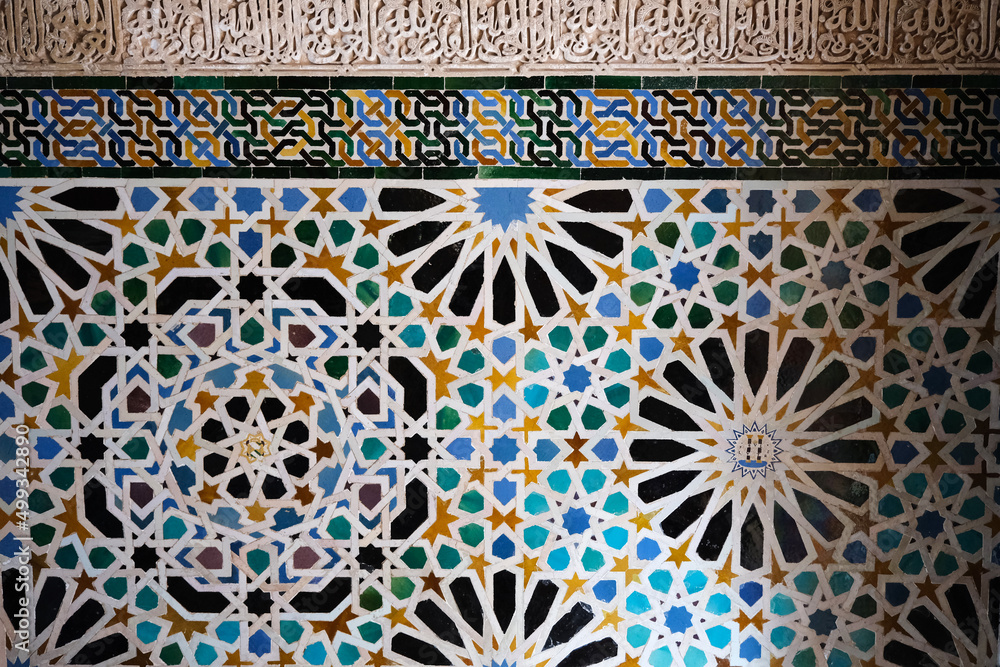 Alhambra, Detailed background of the Alhambra Palace with intricate tile patterns on the wall and arabic writing in the middle. Ceramic wall