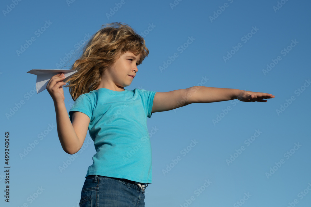 Child boy with paper plane against blue sky. Child dreaming, throwing paper plane, toy airplane. Imagination, kids freedom. Child boy with paper plane against blue sky. Child dreaming, throwing paper plane, toy airplane. Imagination, kids freedom.