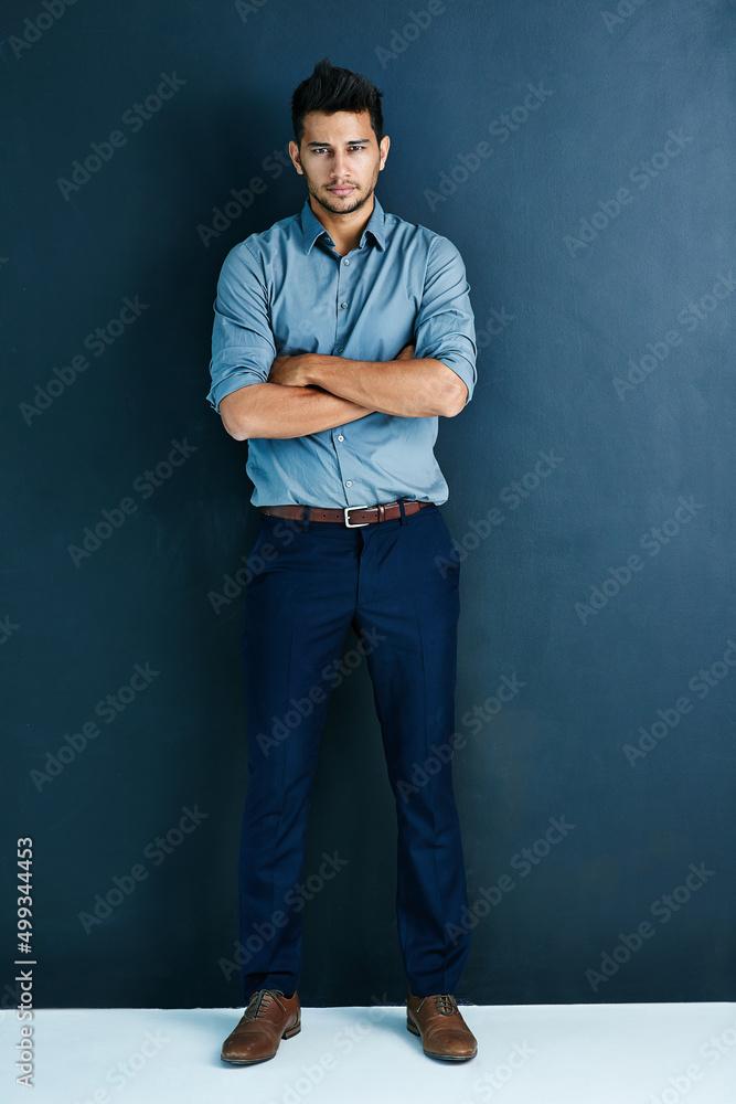 Im not stopping until I reach success street. Studio portrait of a handsome young businessman standing with his arms crossed against a grey background.