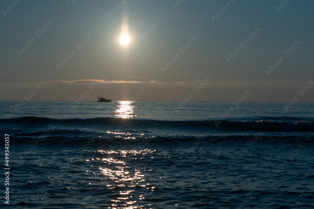 Evening sunset over the sea with a sea boat sailing on the horizon. Evening sunset over the sea with a sea boat sailing on the horizon.