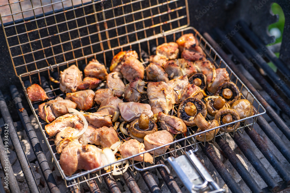 Pork skewers and mushrooms are cooked over an open fire. Pork skewers and mushrooms are cooked over an open fire.
