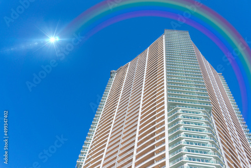 高層ビルと雨上がりの虹がかかった青空