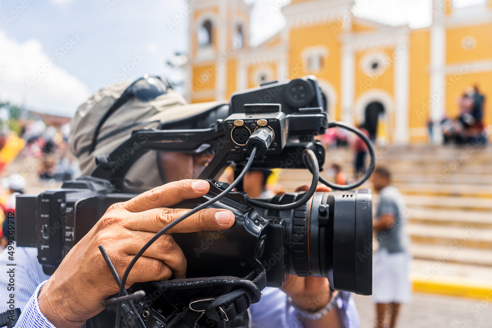Fototapeta premium An unrecognizable cameraman films footage of a religious activity in Nicaragua during Holy Week