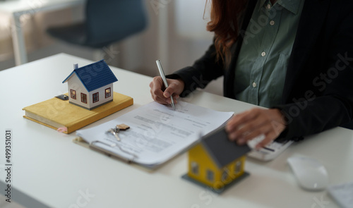 Close up hand of real estate investment and home insurance signing contracts in accordance with the home buying insurance agreements approving purchases for clients