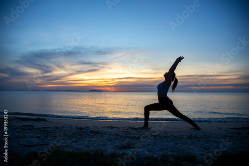 Yoga silhouette. Meditation woman on the ocean during amazing sunset. Fitness and healthy lifestyle.