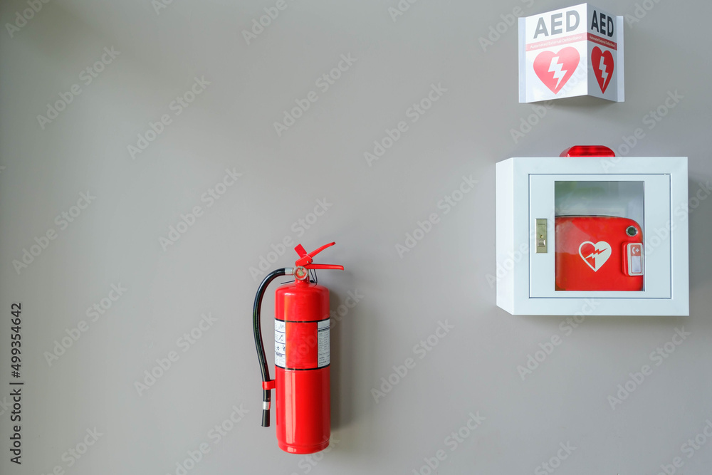 Fire alarm system on a brick an emergency during fire.Automated External Defibrillator AED emergency life saving equipment mounted on wall of rowing club. Fire alarm system on a brick an emergency during fire.Automated External Defibrillator AED emergency life saving equipment mounted on wall of rowing club.