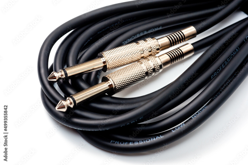 Long black jack cord for electric guitar, filmed on a white background. Long black jack cord for electric guitar, filmed on a white background.