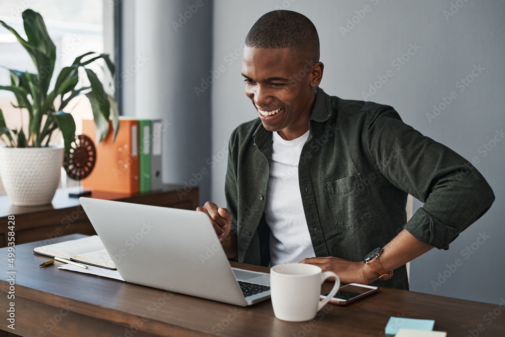 I shouldve been working from home all along. Shot of a young businessman using his laptop while working from home. - obrazy, fototapety, plakaty 