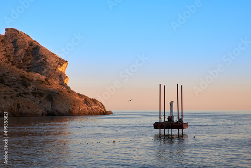 Small sea jack-up barge on legs installed near the shore