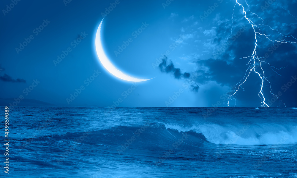 Fototapeta premium Night sky with Blue crescent moon in the clouds on the fore ground strong sea wave 
