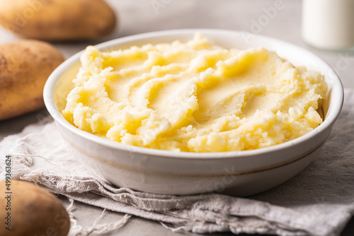 Mashed potatoes in white bowl on grey concrete background. Healthy food