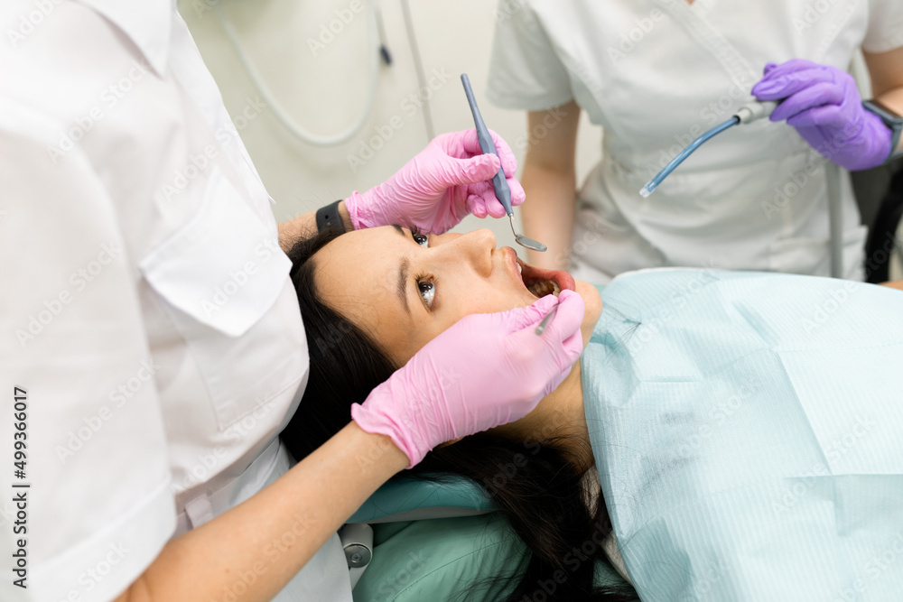 doctor dentist doing medical stomatology examination for woman patient, using professional tools doctor dentist doing medical stomatology examination for woman patient, using professional tools