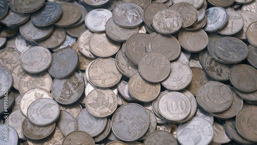 Pile of Indonesian rupiah coins on white background, slight bright light