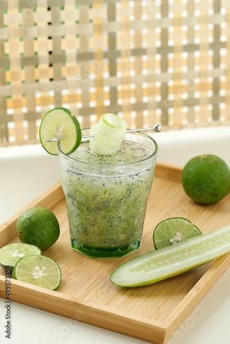 Es Timun Serut made from Shredded Cucumber, Lime Juice, and Basil Seeds, Served on Clear Glass on Wooden Table photo