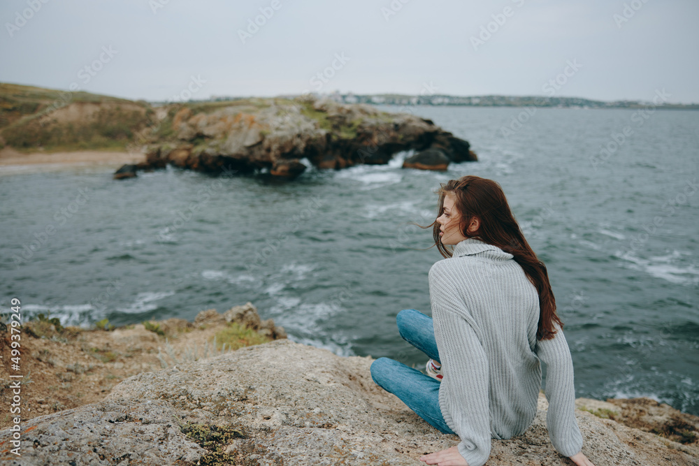 beautiful woman seated on the coast sweater landscape unaltered