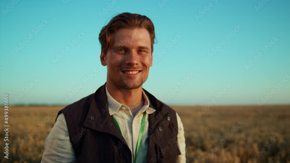 Portrait smiling agricultural worker posing at golden husbandry field alone. Portrait smiling agricultural worker posing at golden husbandry field alone.