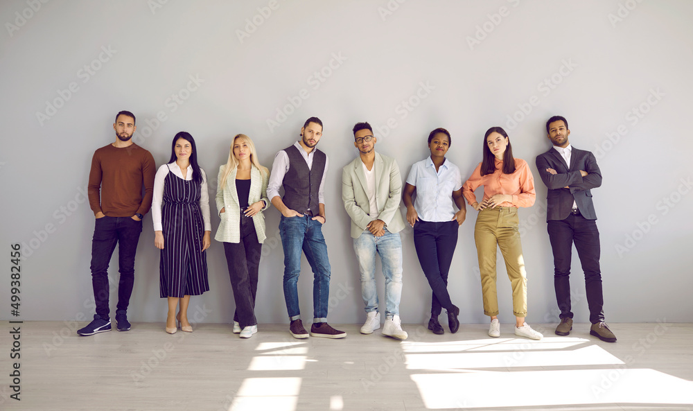Obraz premium Portrait of diverse multiethnic businesspeople pose near grey wall background show unity and leadership. Multicultural employees or colleagues demonstrate diversity at workplace. Teamwork concept.
