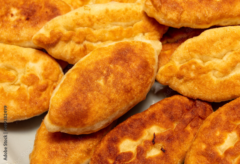 Pies are fried in oil in a frying pan. Pies are fried in oil in a frying pan.