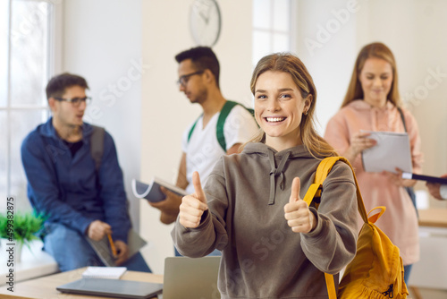 Portrait of smiling teen schoolgirl show thumb up give recommendation to school or college. Happy female student with backpack recommend good courses or training. Education concept.