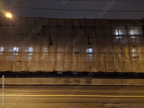 multi storey building during renovation covered with fabric at night. photo