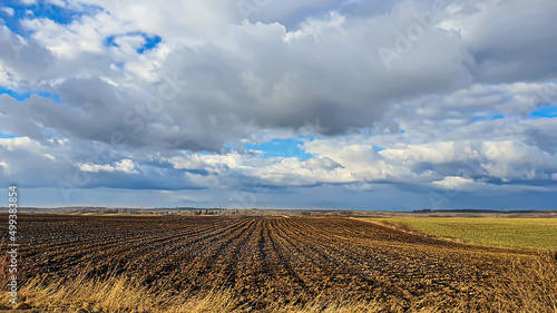 Sowing time in Ukraine during the war. Preparing fields for sowing grain. Blue sky  plowed land. terror.