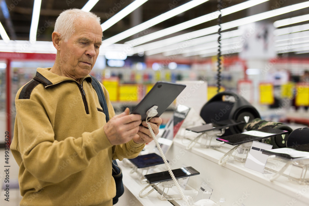 senor man pensioner buying modern tablet digital in showroom of digital electronic goods store senor man pensioner buying modern tablet digital in showroom of digital electronic goods store
