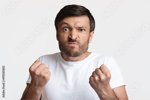 Angry Man Clenching Fists Ready To Fight Over White Background