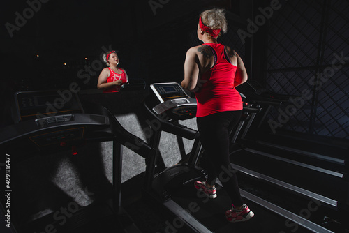 Fat or obese woman or girl jogging on treadmill. Weight loss program sign or symbol. Cardio workout. Obesity concept. Running lady. Sport motivation. © Oleg