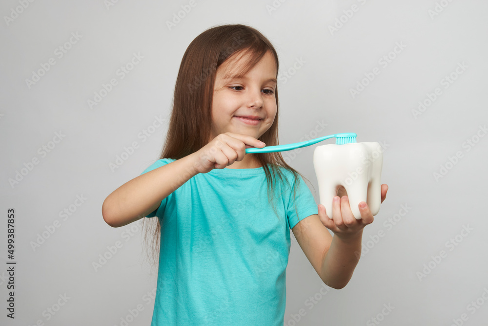 Child girl brushing teeth, white background with copy space Child girl brushing teeth, white background with copy space