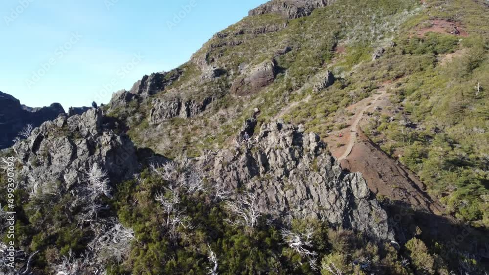 Flight over the slopes of the highest mountain in Madeira, Pico Ruivo. Circle view around the adventurers sitting on the rock. Aerial view of the mountain range. 4k video Flight over the slopes of the highest mountain in Madeira, Pico Ruivo. Circle view around the adventurers sitting on the rock. Aerial view of the mountain range. 4k video