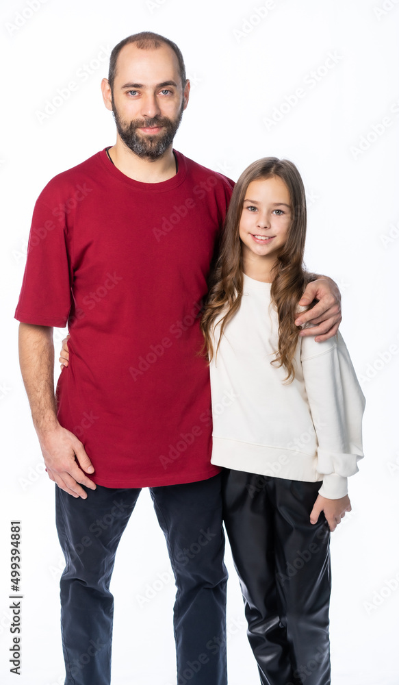 dad hugs daughter by the shoulders in the studio. a man in a burgundy-red T-shirt, a girl in a white sweatshirt. isolated white background dad hugs daughter by the shoulders in the studio. a man in a burgundy-red T-shirt, a girl in a white sweatshirt. isolated white background
