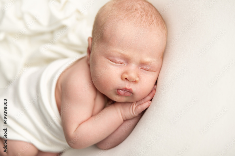 Newborn baby sleeping on a white blanket Newborn baby sleeping on a white blanket