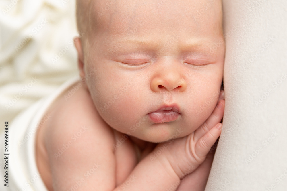 Newborn baby sleeping on a white blanket Newborn baby sleeping on a white blanket
