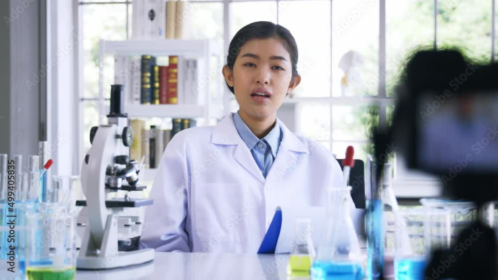Portrait of young female doctor wearing lab coat recording online video class and vlog on medical research and science experiments in laboratory Portrait of young female doctor wearing lab coat recording online video class and vlog on medical research and science experiments in laboratory