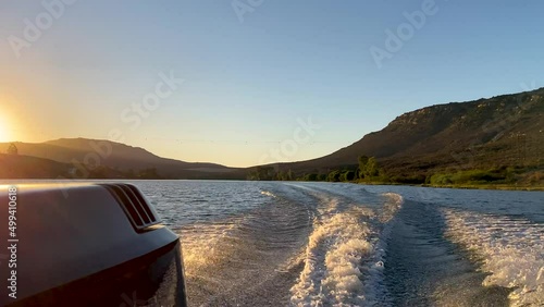 Speed boat wake at sunset on Bulshoek Dam, South Africa photo