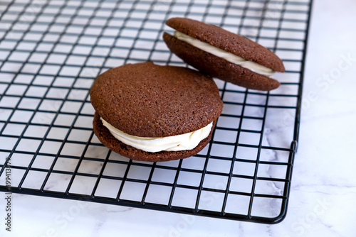 Homemade chocolate sandwich cookies. Light marble background.