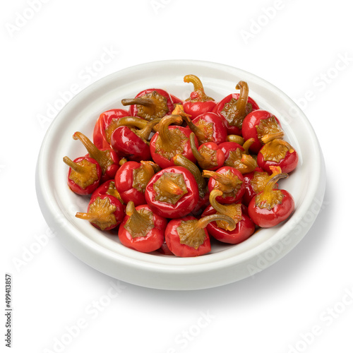 Bowl with pickled Red Cherry chili peppers close up isolated on white background