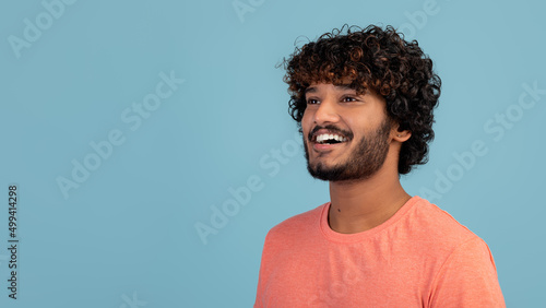 Cheerful hindu guy looking at copy space
