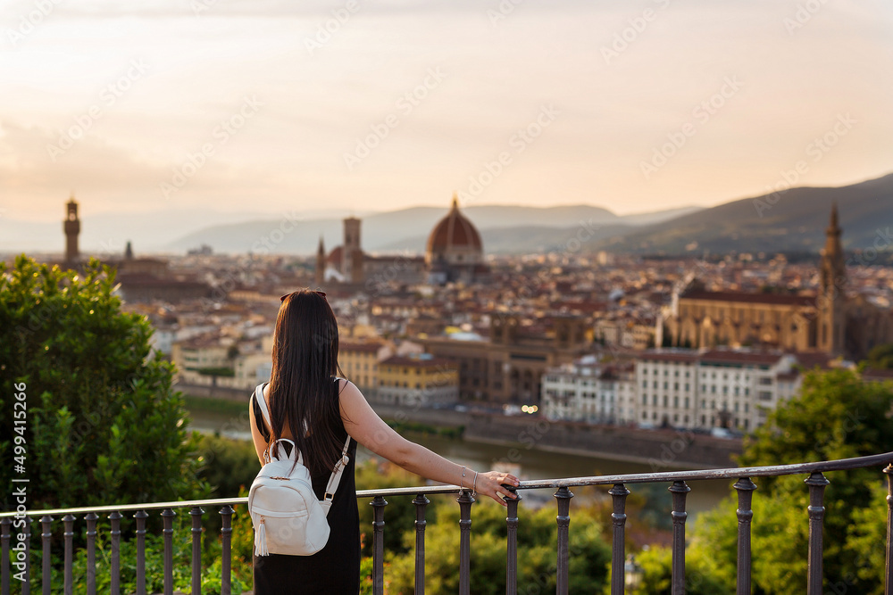 Young woman tourist watching Florence and Cathedral of Santa Maria Del Fiore. Vacation concept with view of Firenze, Italy from Piazzale Michelangelo.