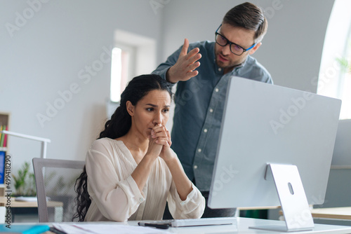 Angry boss scolding female employee for making error in business project at office. Workplace stress concept