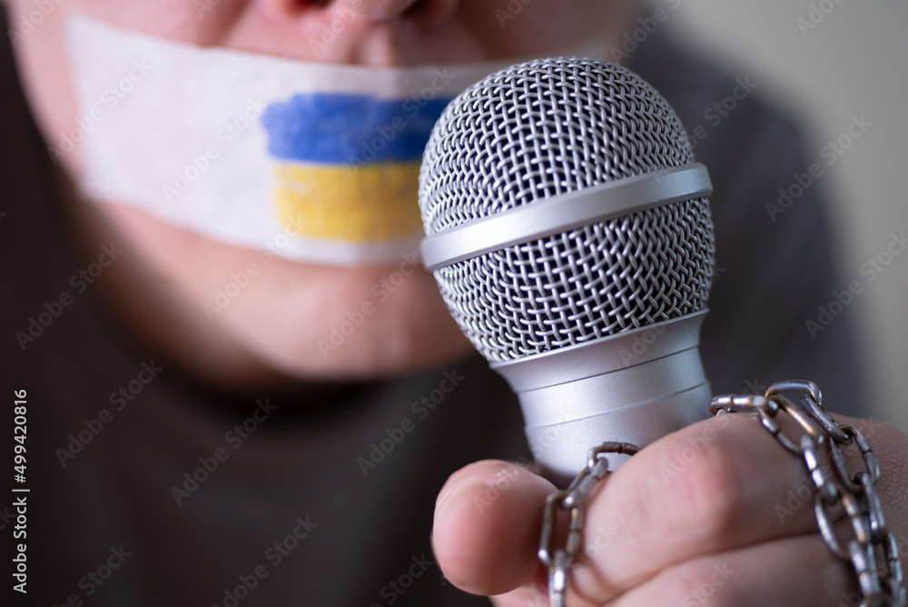 Tape over his mouth with the flag of Ukraine, trying to speak into a  microphone. Stock Photo | Adobe Stock