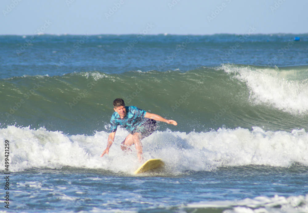 beginner surfer in a wave at matadeiro beach, Florianópolis, Brazil