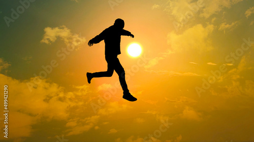 Wallpaper Mural 夕日の前でジャンプする男性のシルエット_ワイド Torontodigital.ca