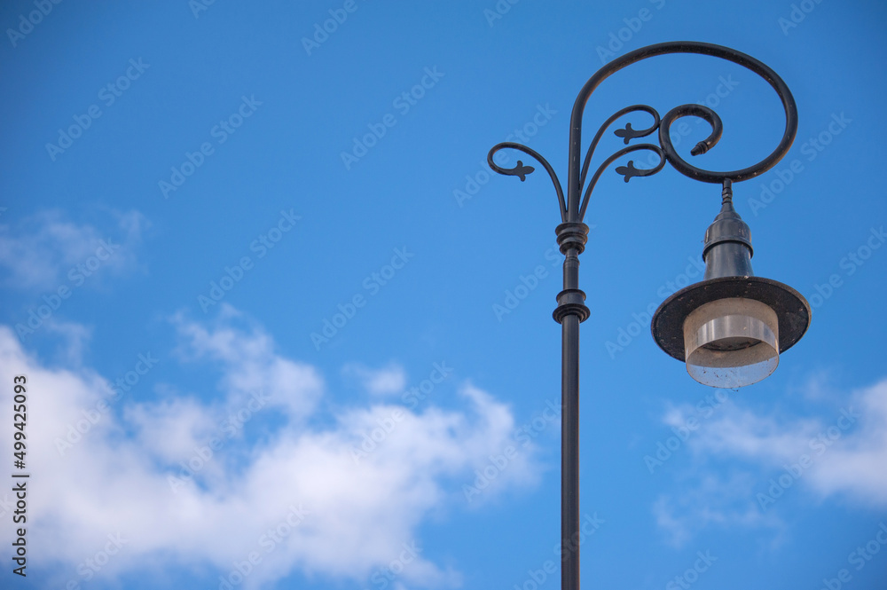 Beautiful forged lantern in the old city against the blue sky Beautiful forged lantern in the old city against the blue sky