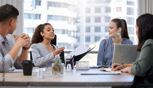 Shes got them hanging on her every word. Shot of a group of businesspeople having a meeting in an office at work.