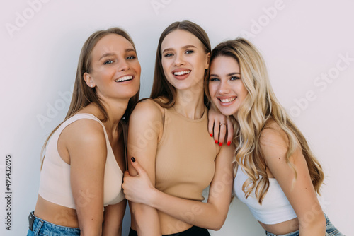 Group of women laughing together on white background.