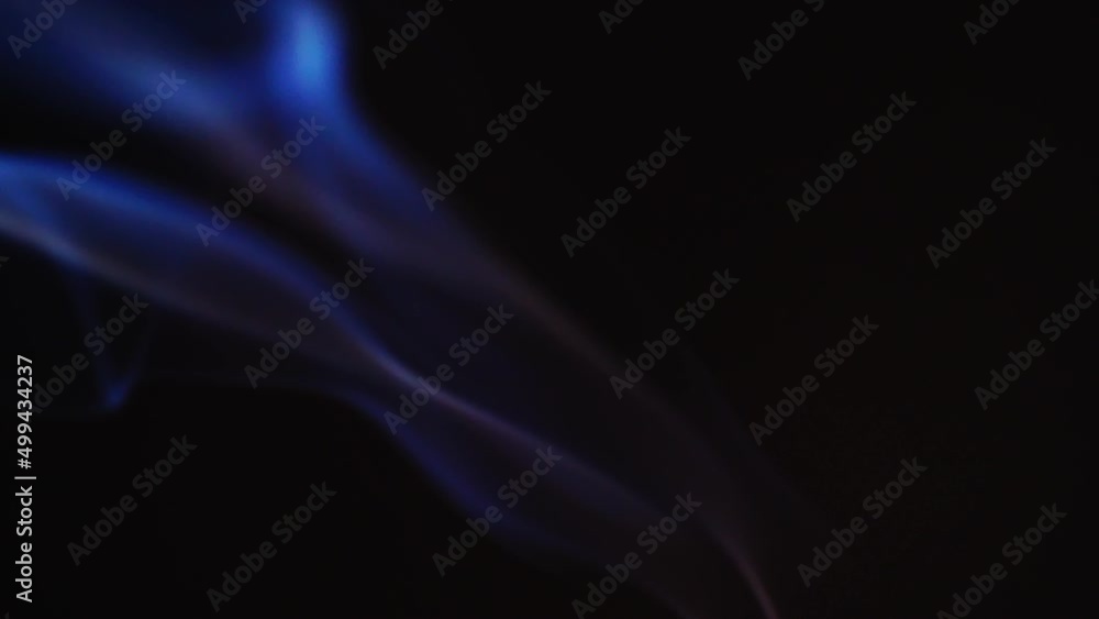 Abstract blue color smoke with a black background in slow motion. Realistic cloud smoke with a streamlined pattern. Abstract blue color smoke with a black background in slow motion. Realistic cloud smoke with a streamlined pattern.