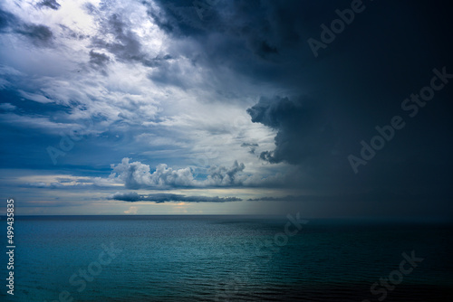 Dark thunderstorm clouds with rain over ocean