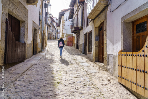 Woman walking through an alley with old medieval houses, Candelario Salamanca. photo